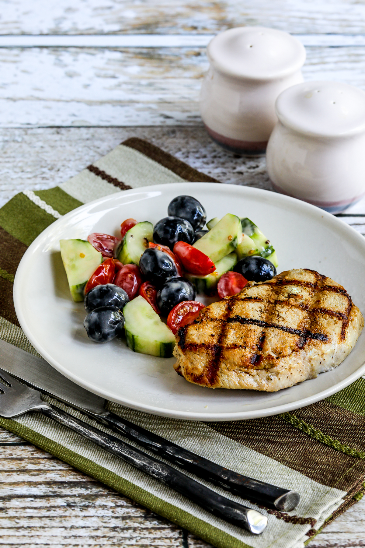 Grilled Boneless Pork Chops shown on serving plate with salad.