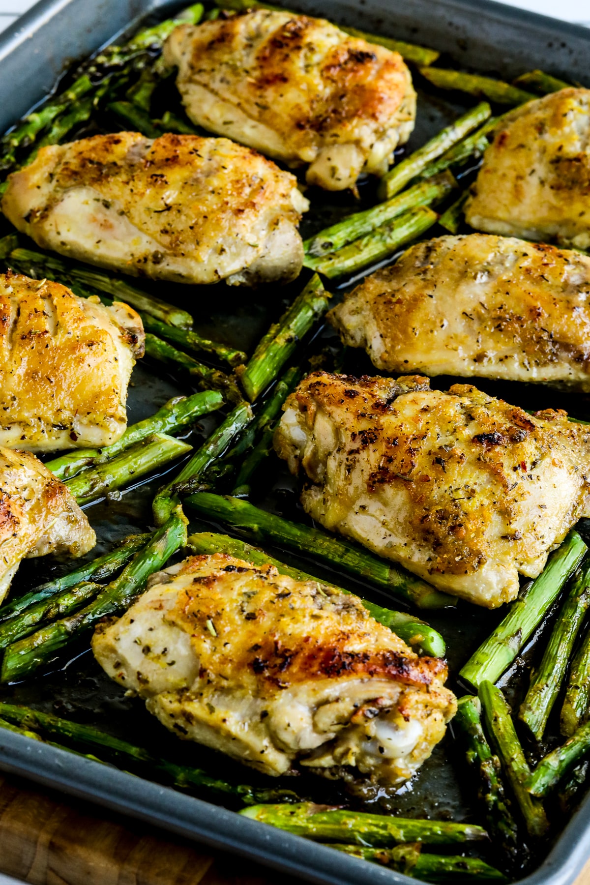 Finished Sheet Pan Chicken Thighs and Asparagus shown on sheet pan.