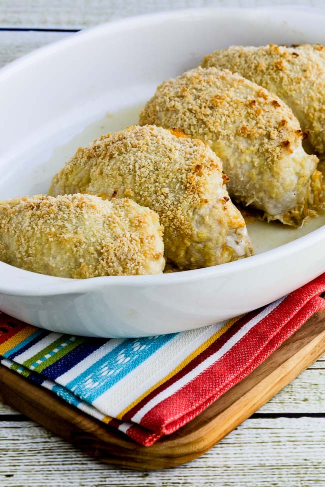 Baked Stuffed Chicken Breast with Green Chiles and Cheese shown in baking dish on striped napkin