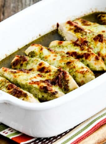 square image of Easy Baked Pesto Chicken in baking dish on striped napkin