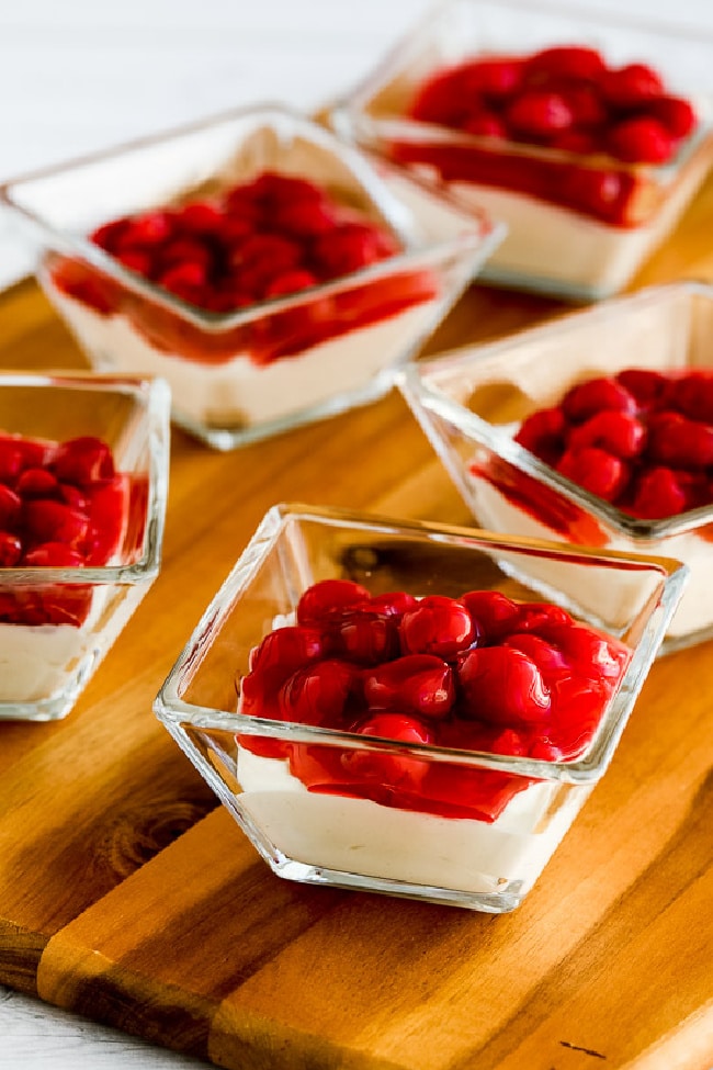 Low-Carb No Bake Cherry Cheesecake Dessert closer view of dishes filled with no-bake cheesecake on cutting board